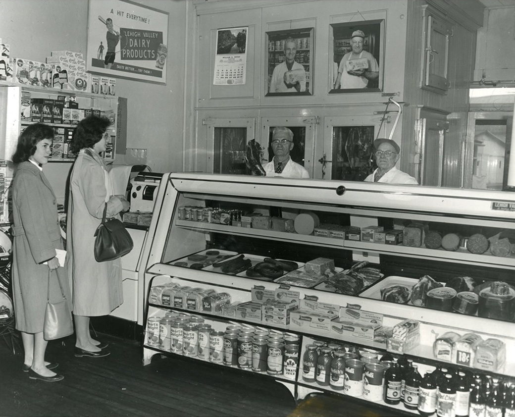 Two women browse the selections in the case at Luckenbill's Butcher Shop, as two employees wait for their orders. This photo was taken in the 1950s.