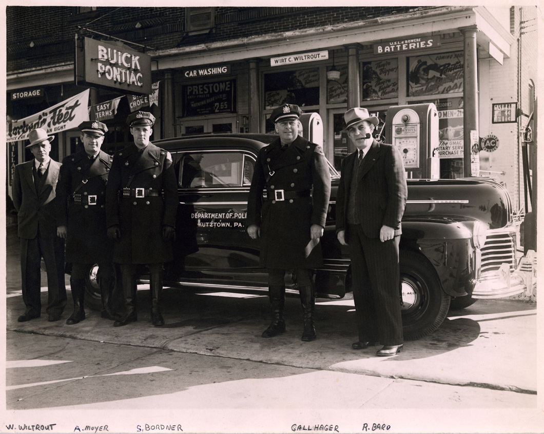 Original grayscale photo of new police cruiser, with five members of police department in front
